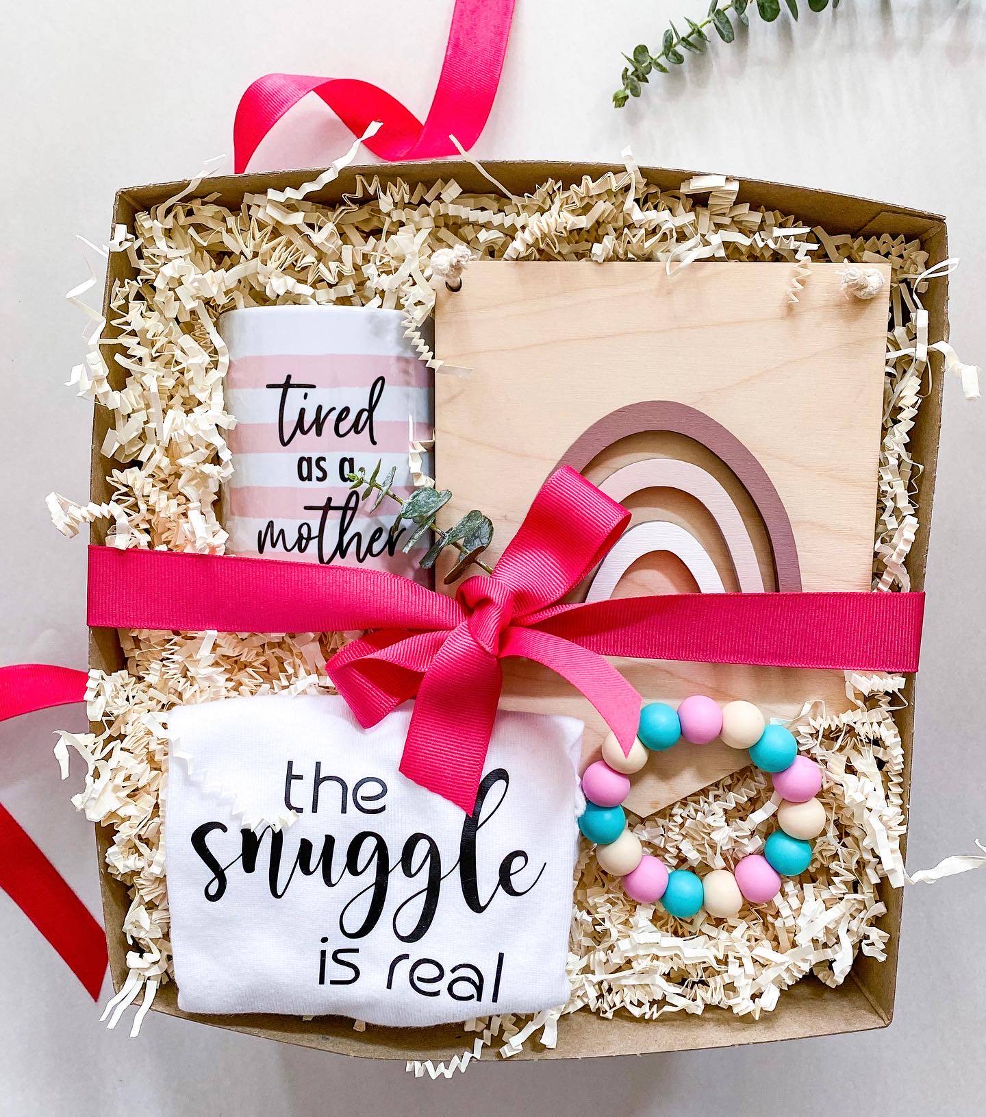 The snuggle is real baby onesie in a custom gift box canada created for new moms. Includes Tired as a Mother much and baby chew toy